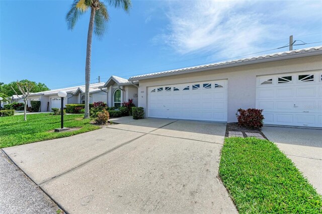 ranch-style home with a garage and a front lawn