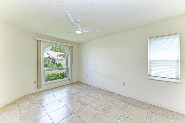 empty room featuring ceiling fan, a textured ceiling, and light tile floors