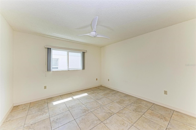 empty room with ceiling fan, a textured ceiling, and light tile flooring