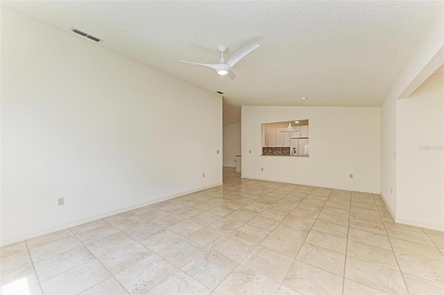 tiled spare room with a textured ceiling, ceiling fan, and vaulted ceiling