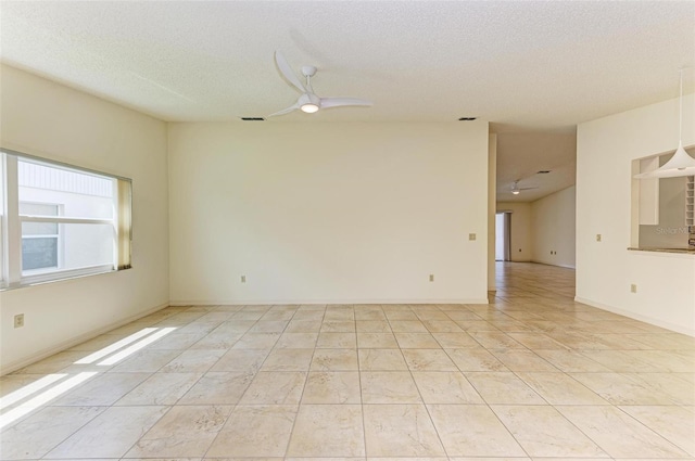 tiled spare room featuring ceiling fan and a textured ceiling