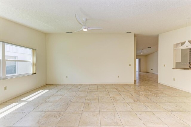 empty room featuring a textured ceiling and ceiling fan