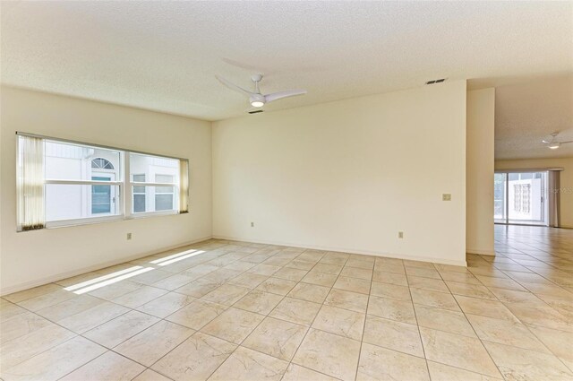 tiled spare room featuring a textured ceiling and ceiling fan