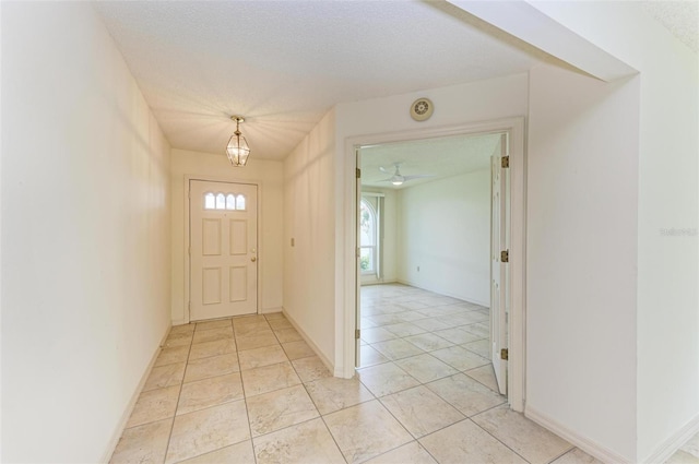 entryway with a textured ceiling and light tile floors