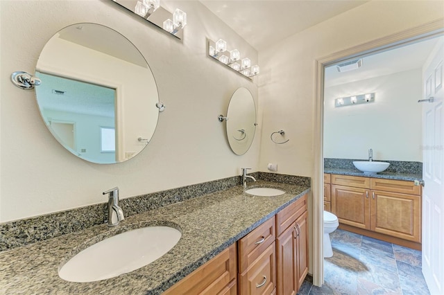 bathroom featuring dual vanity, tile flooring, and toilet