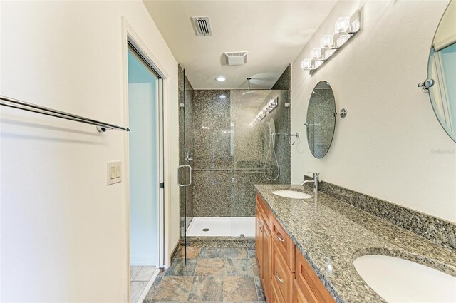 bathroom with double vanity, tile flooring, and walk in shower