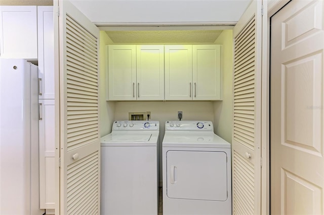 laundry room featuring electric dryer hookup, cabinets, washer hookup, and washing machine and clothes dryer