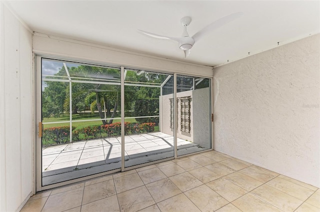 tiled empty room featuring ceiling fan