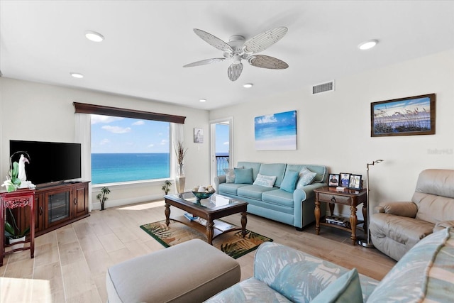 living room featuring a water view, ceiling fan, and light hardwood / wood-style flooring