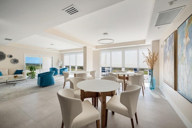 tiled dining space with a tray ceiling