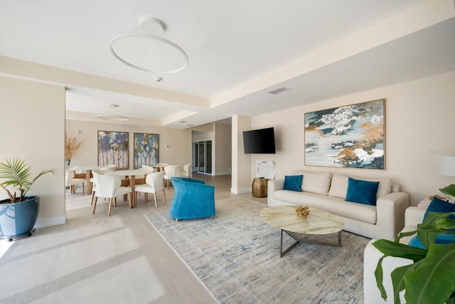 tiled living room featuring a raised ceiling