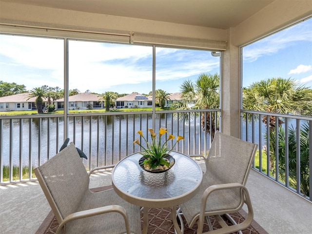 sunroom featuring a water view