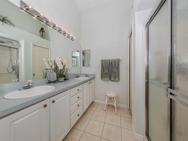 bathroom featuring tile patterned floors, vanity, and a shower with shower door