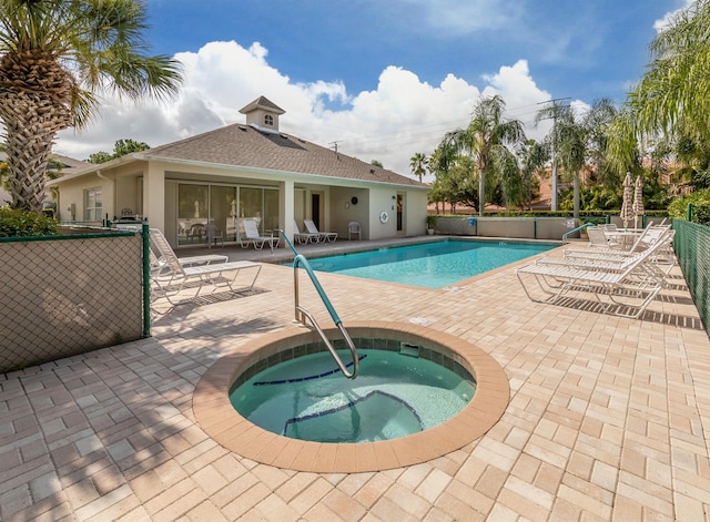 view of swimming pool featuring a patio and a hot tub