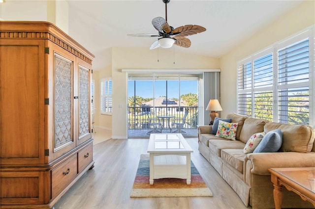 living room featuring ceiling fan, light hardwood / wood-style floors, and lofted ceiling