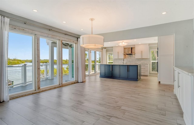 unfurnished living room featuring light wood-type flooring and a wealth of natural light