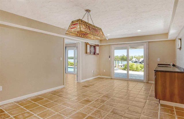 unfurnished room featuring sink and light tile floors