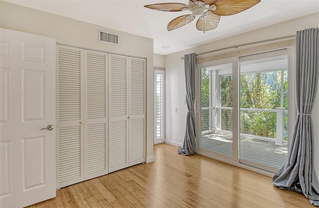 unfurnished bedroom with a closet, light hardwood / wood-style floors, ceiling fan, and access to exterior