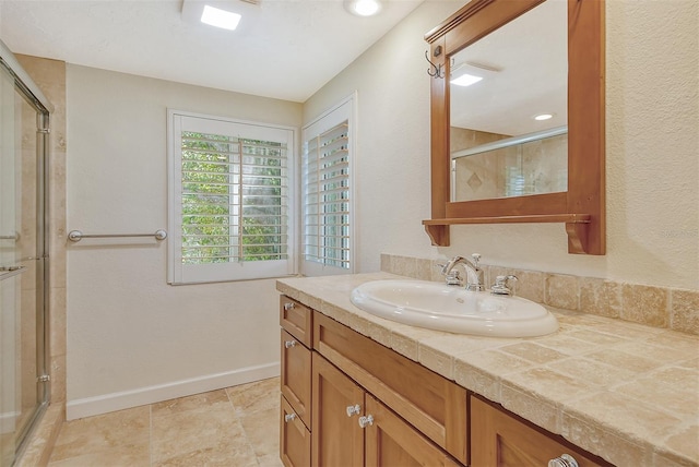 bathroom with an enclosed shower, vanity, and tile floors