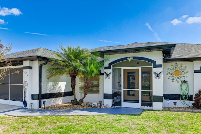 back of property with a lawn and a sunroom