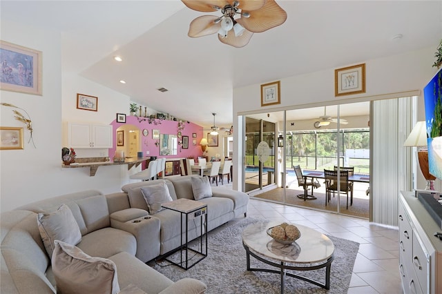 living room featuring lofted ceiling, light tile floors, and ceiling fan