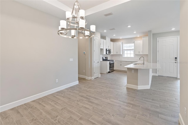 kitchen with hanging light fixtures, a notable chandelier, sink, stainless steel appliances, and white cabinets