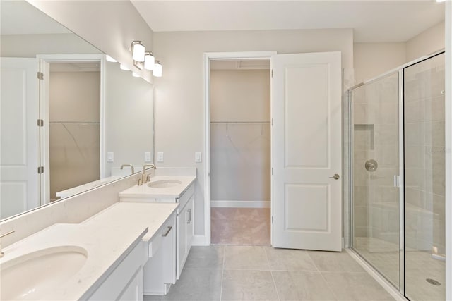 bathroom with double sink, tile flooring, a shower with shower door, and oversized vanity