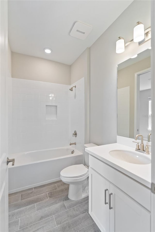 full bathroom with tiled shower / bath combo, oversized vanity, and toilet