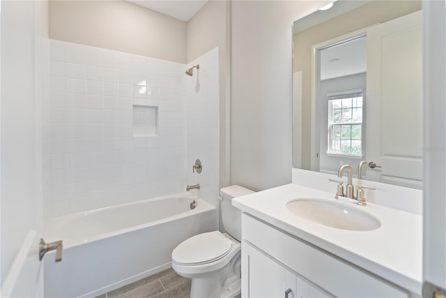 full bathroom with tiled shower / bath combo, tile flooring, vanity with extensive cabinet space, and toilet