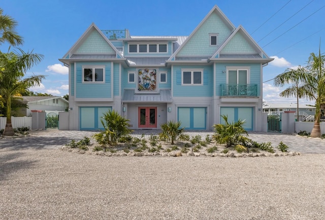 view of front of property featuring french doors, an attached garage, decorative driveway, and a gate