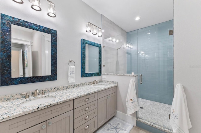 bathroom featuring a shower with door and vanity