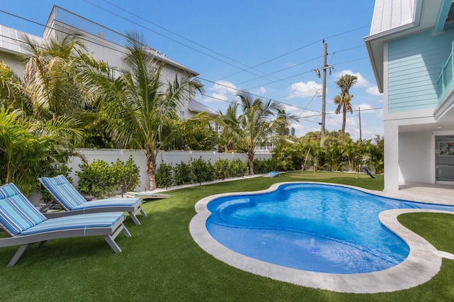 view of swimming pool with a yard