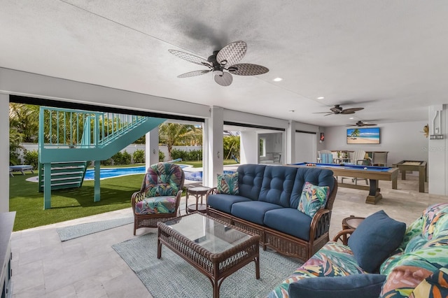 tiled living room featuring a textured ceiling, ceiling fan, and billiards