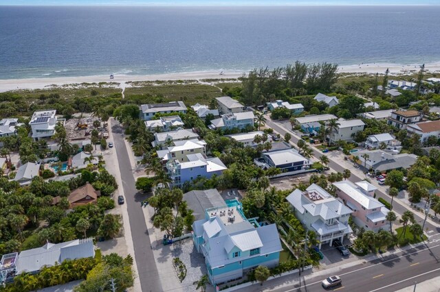 birds eye view of property featuring a water view and a beach view