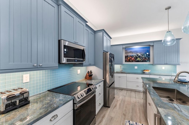 kitchen featuring light hardwood / wood-style flooring, stainless steel appliances, decorative backsplash, and sink