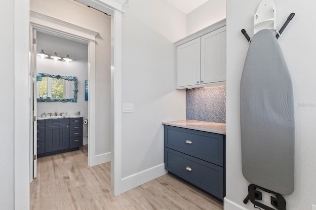 bathroom with decorative backsplash, vanity, and hardwood / wood-style flooring