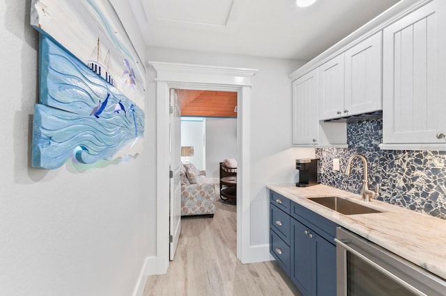 kitchen with white cabinets, sink, tasteful backsplash, dishwasher, and light hardwood / wood-style floors