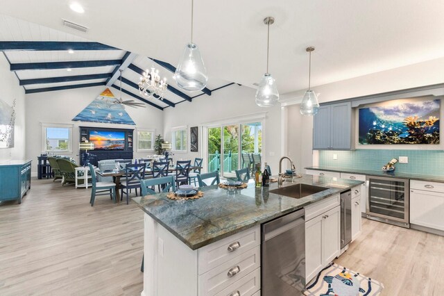 kitchen with lofted ceiling with beams, wine cooler, a kitchen island with sink, sink, and stainless steel dishwasher