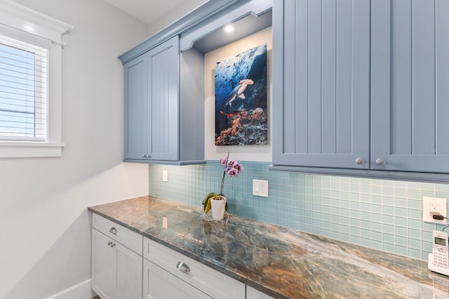 interior space featuring dark stone counters and backsplash