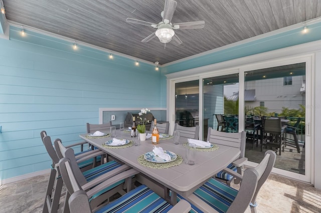 dining room featuring wood walls, ceiling fan, and track lighting