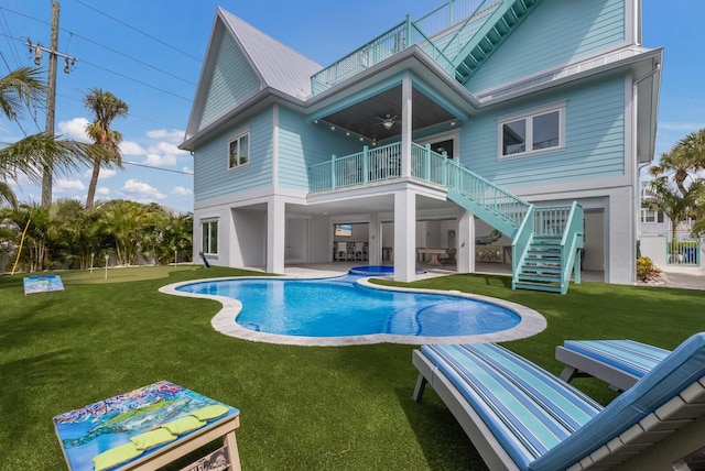 rear view of house with a balcony, a yard, and a patio