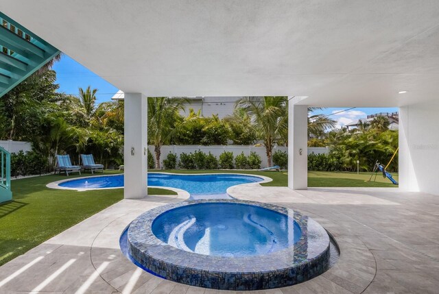 view of pool with an in ground hot tub, a patio, and a lawn