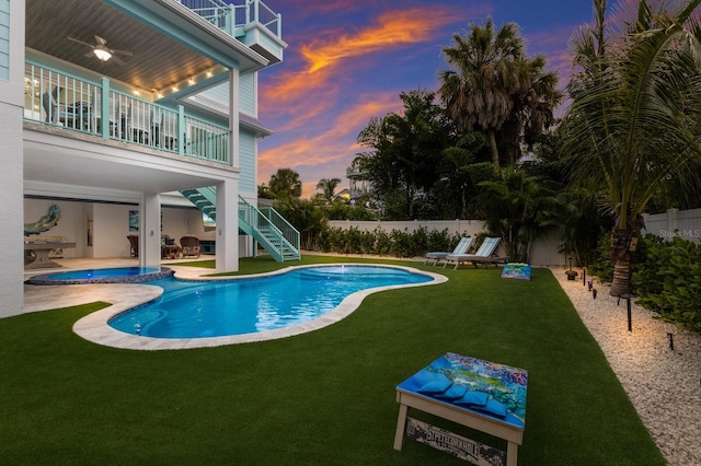 pool at dusk with a lawn and a patio