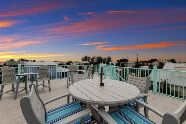 patio terrace at dusk featuring a balcony