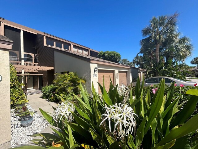 view of side of property featuring a balcony and a garage