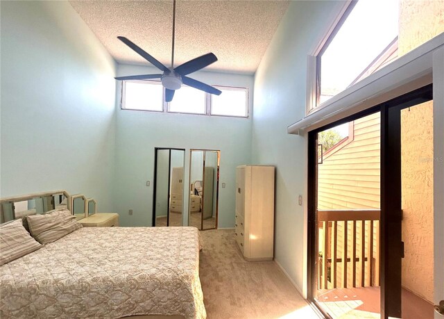 bedroom with high vaulted ceiling, a textured ceiling, light colored carpet, and ceiling fan