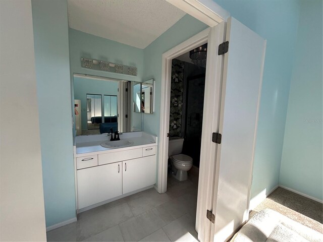 bathroom featuring vanity, a textured ceiling, and toilet