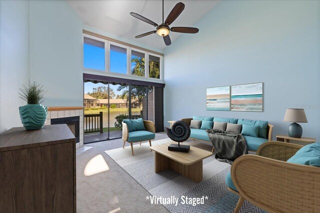 living room featuring light carpet, high vaulted ceiling, a fireplace, and ceiling fan