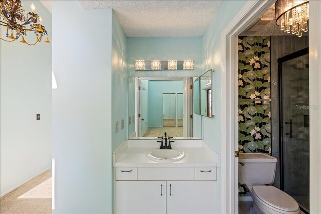 bathroom featuring vanity, a shower with shower door, a textured ceiling, and toilet