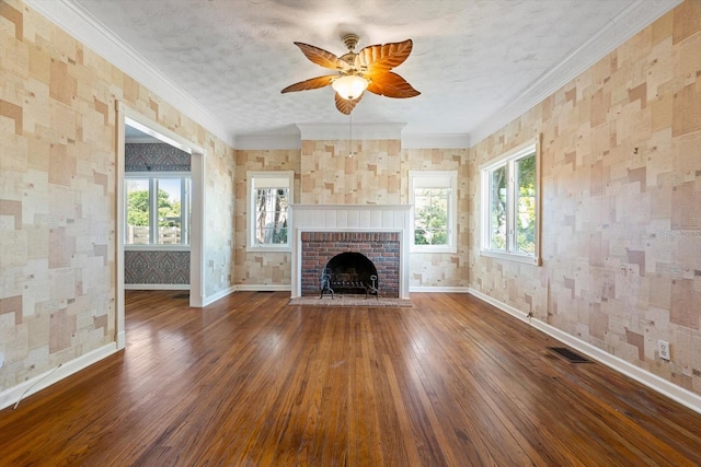 unfurnished living room featuring a textured ceiling, dark hardwood / wood-style floors, crown molding, and a brick fireplace